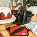 Lodge Cast Iron Fluted Cake Pan with Red Potholders - Cookware Handle Accessory